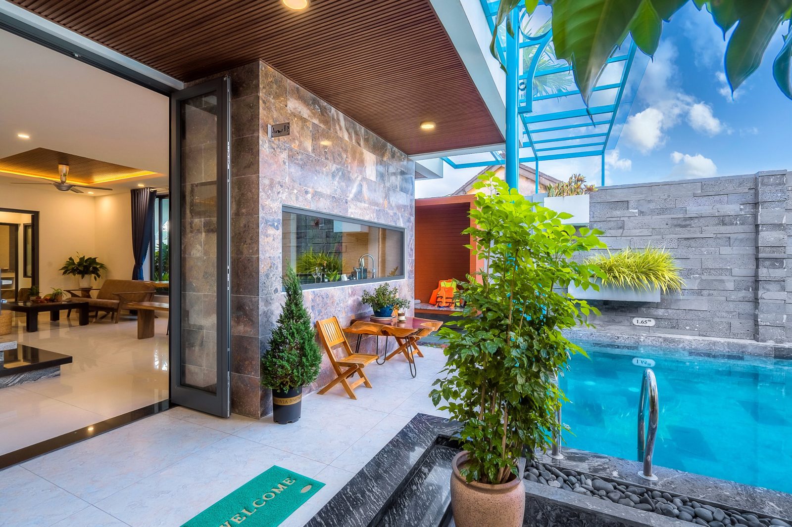 Blue pool with sun loungers on a tiled terrace outside villa B3
