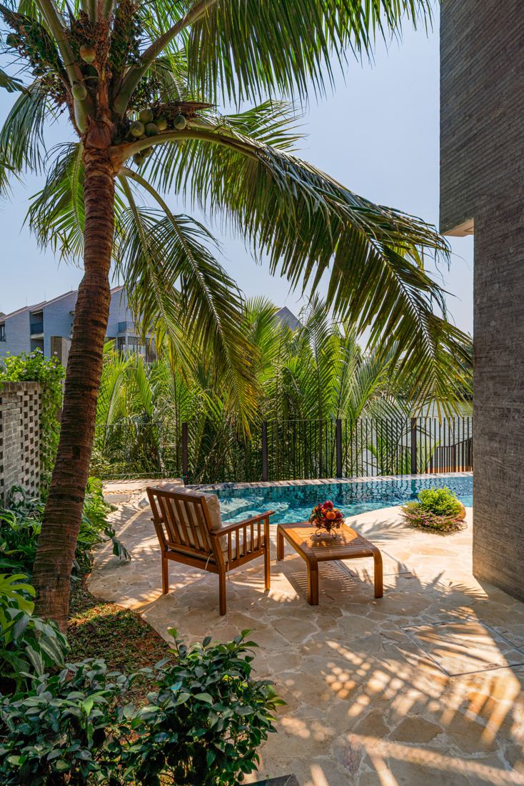 Casamia SL1.3 pool corner under coconut palms with wooden furniture
