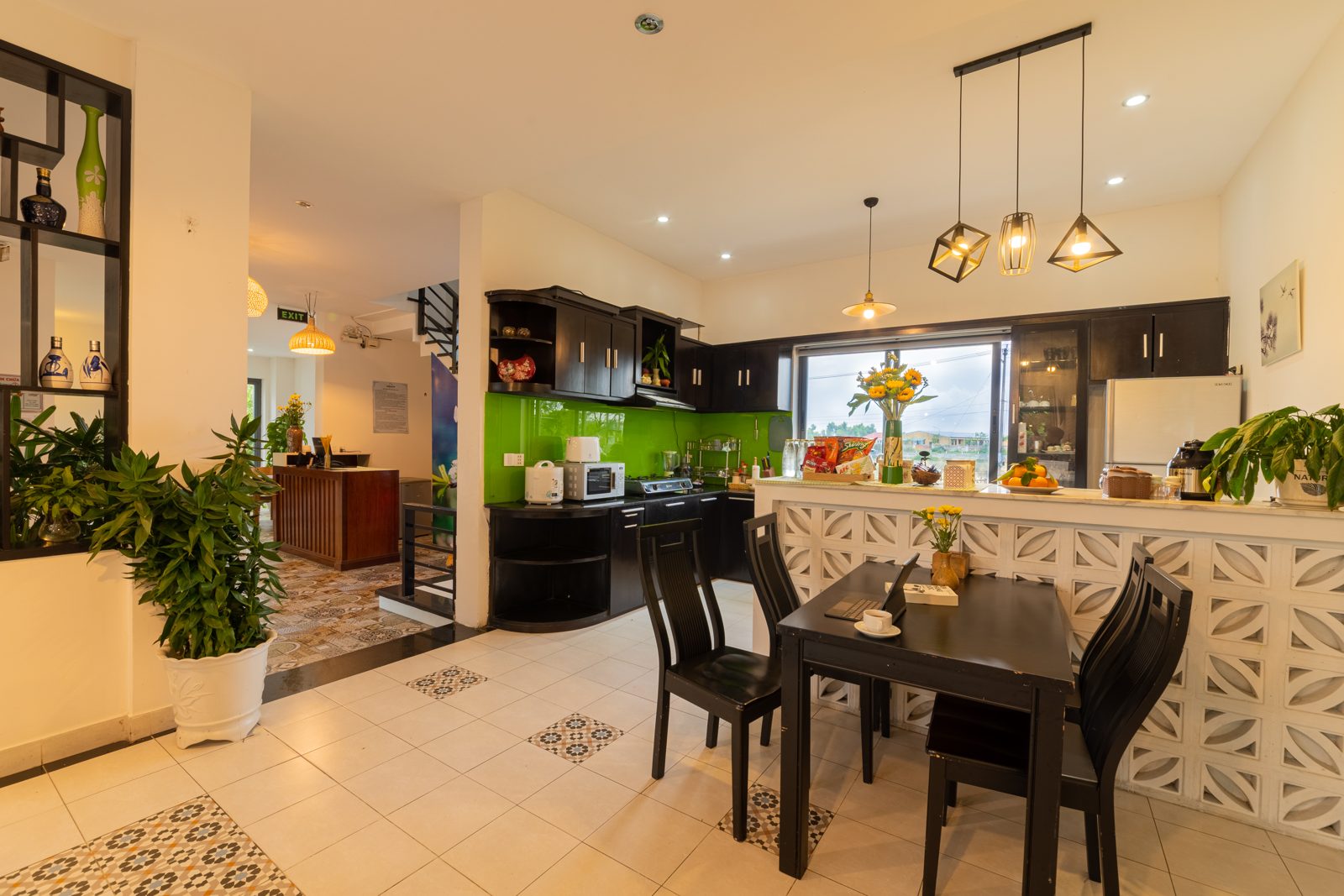Open kitchen with green splashback and breakfast bar