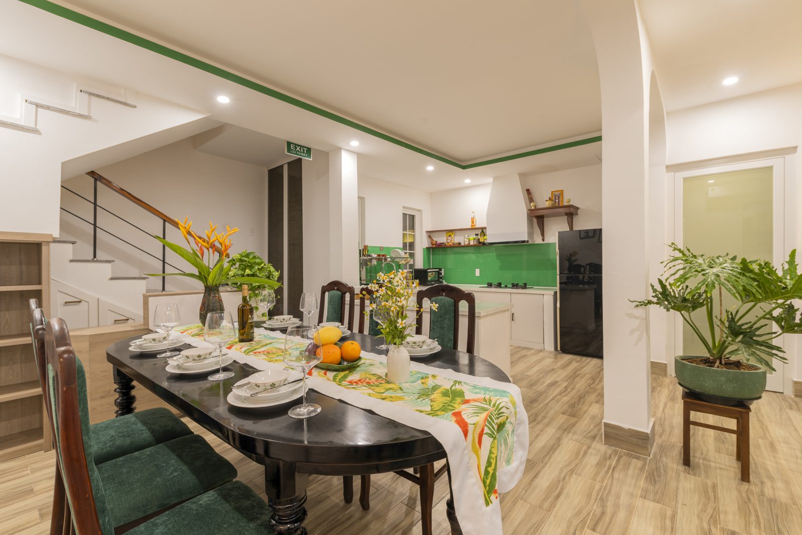 Dining table set for a meal beside the open kitchen