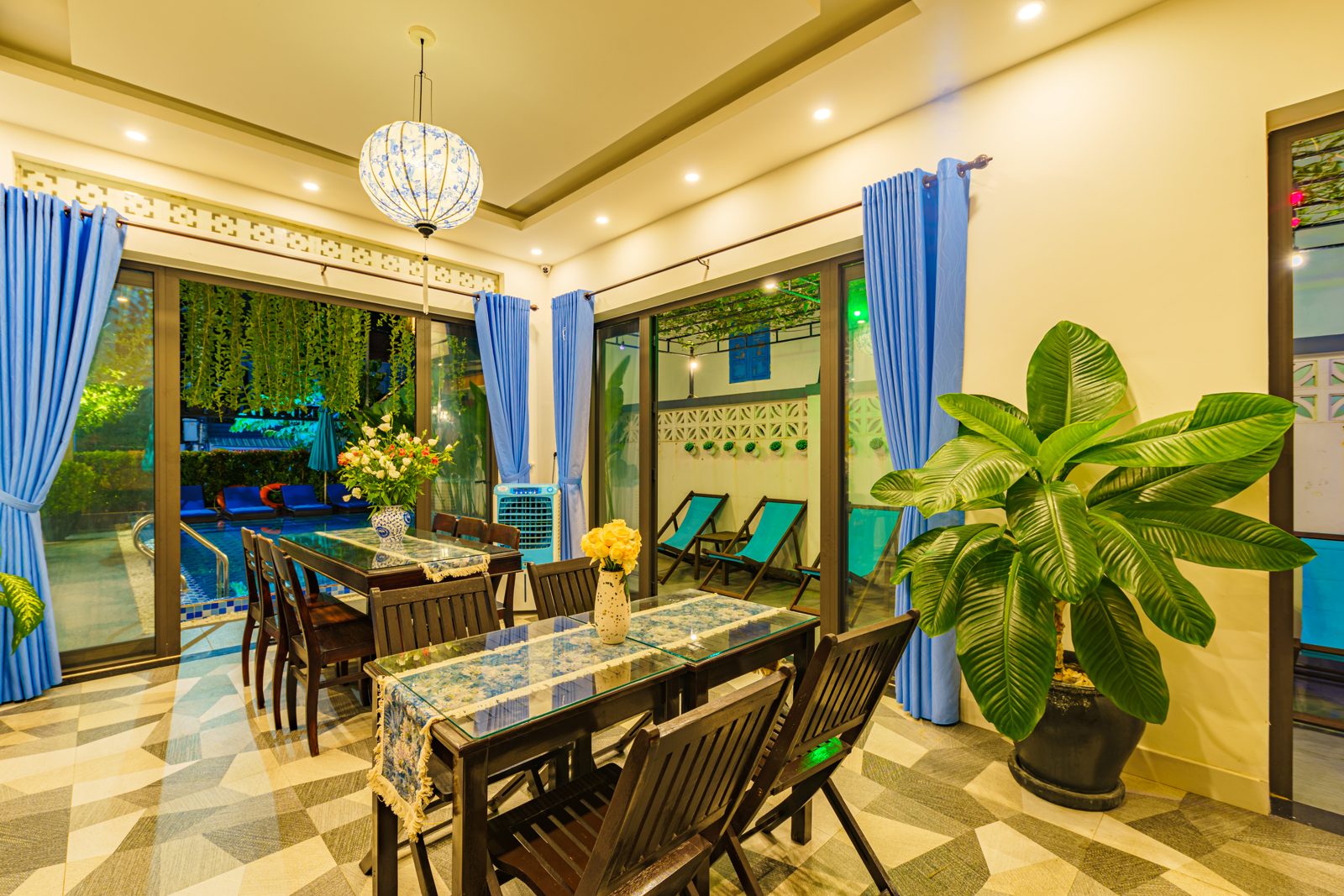 Dining table beside glass doors opening onto the pool