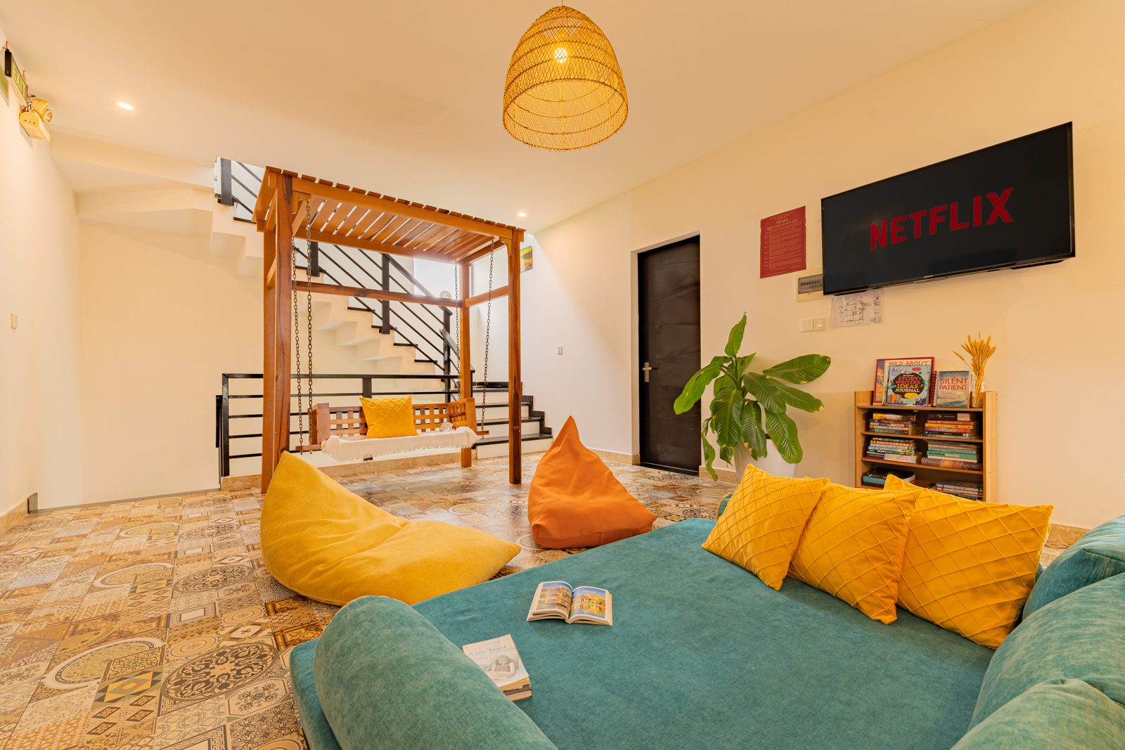Living room with teal day bed, yellow cushions and bean bags