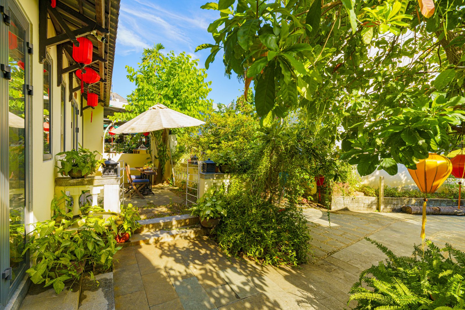 Garden path with red lanterns, plants and a white umbrella