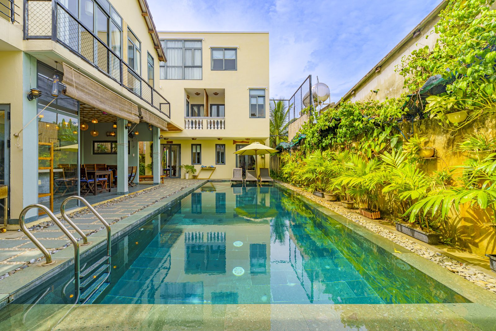 Pool beside the villa buildings with a planted wall
