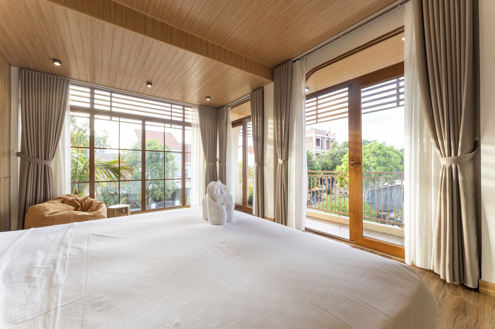 Bedroom with corner windows and a balcony door