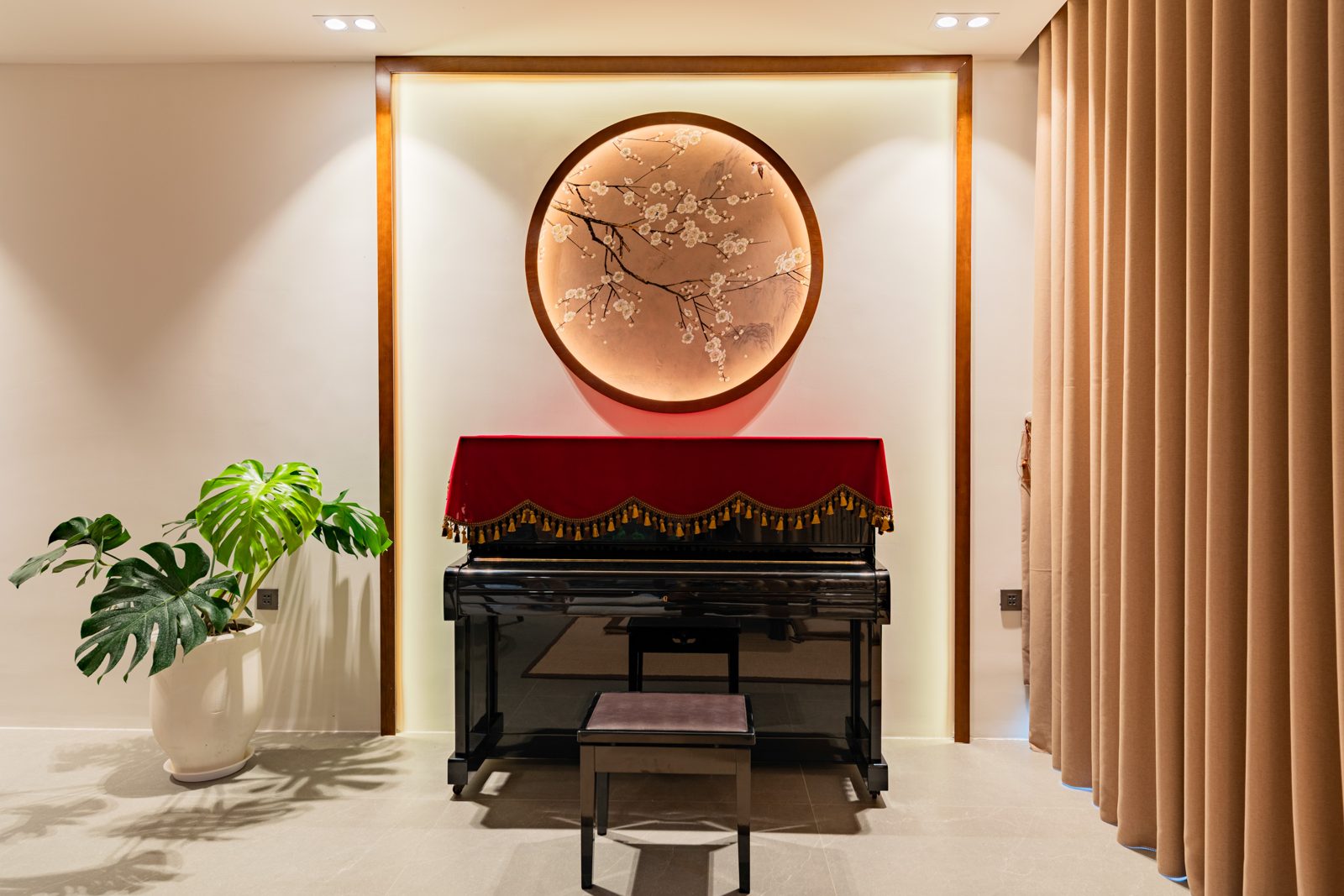 Upright piano under a round lacquer artwork