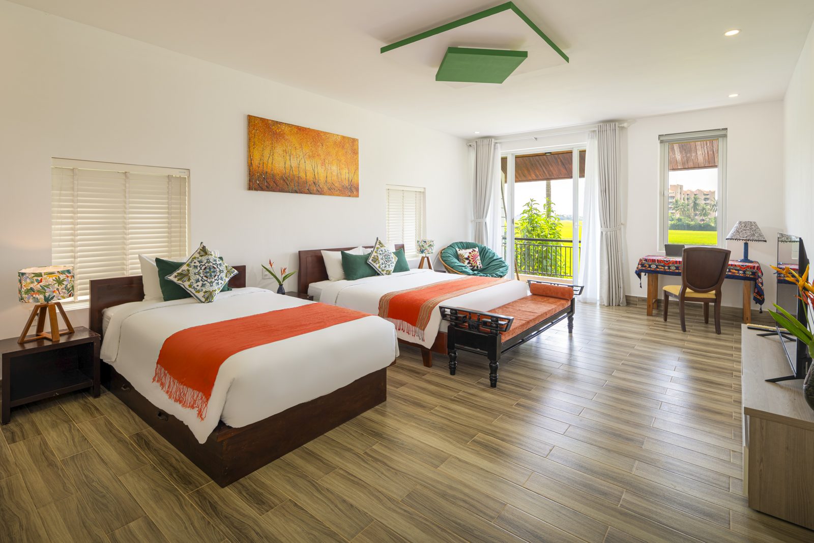 Large bedroom with two beds and orange throws