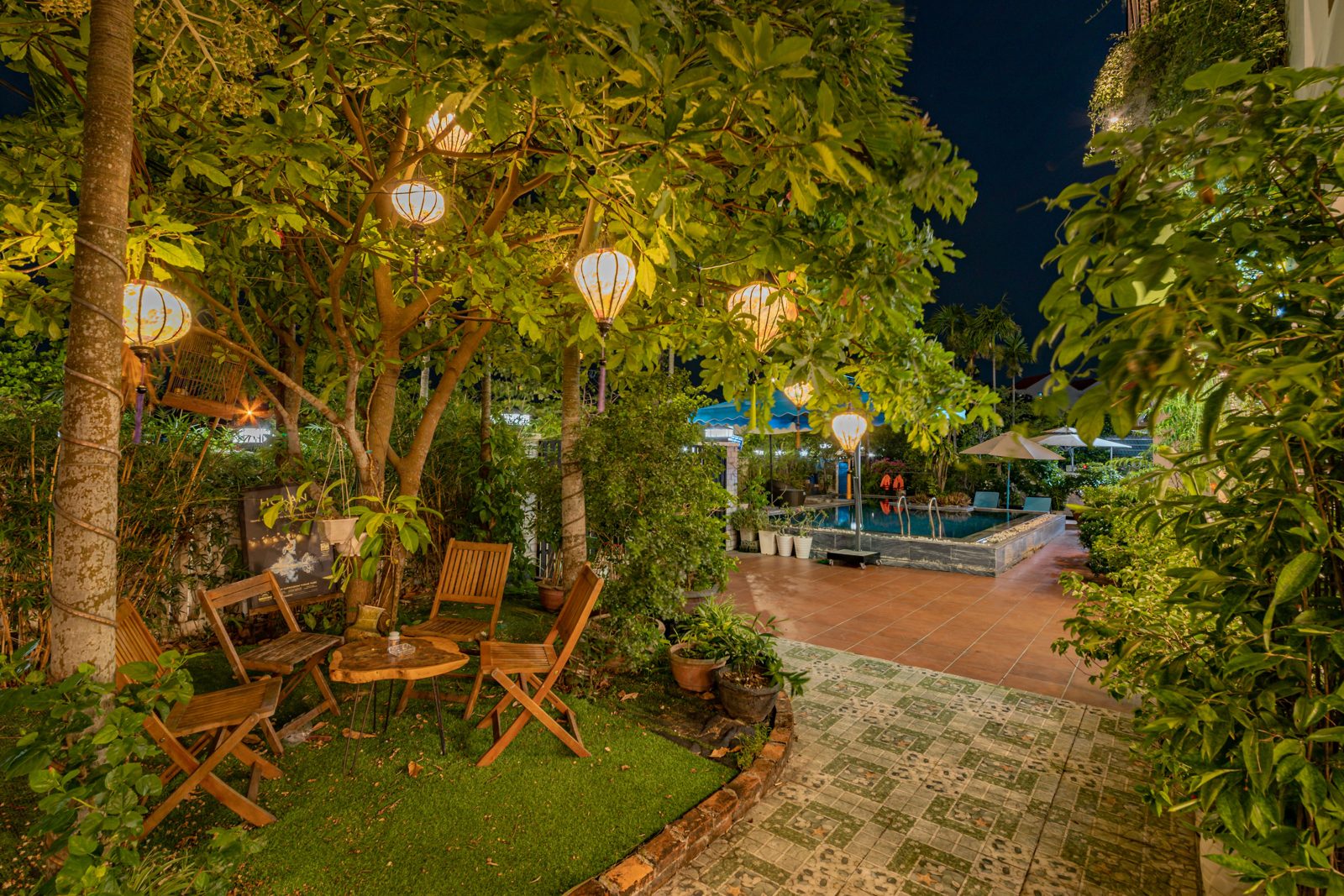 Garden table under lanterns and trees at night