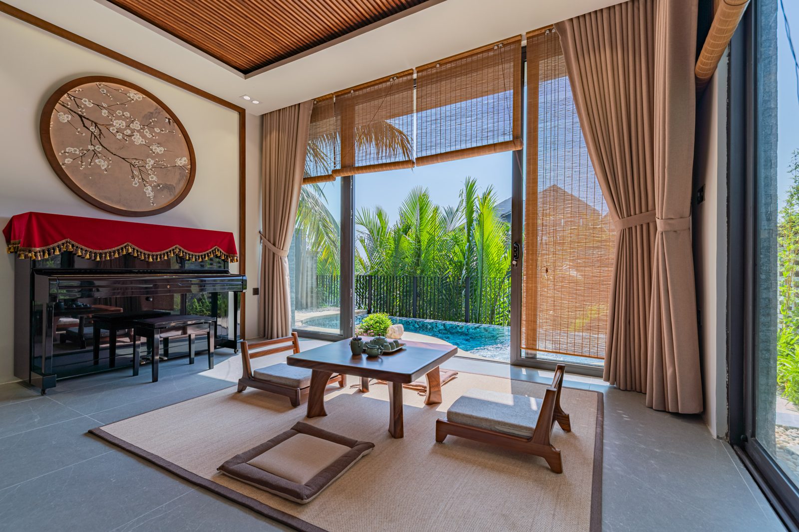 Living room with a low tea table and glass doors onto the pool and palms