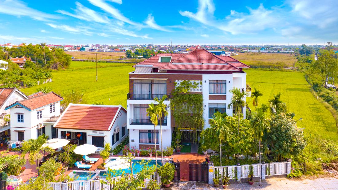 Gateway Inn Hội An from above: red-tiled villa, pool and green rice fields