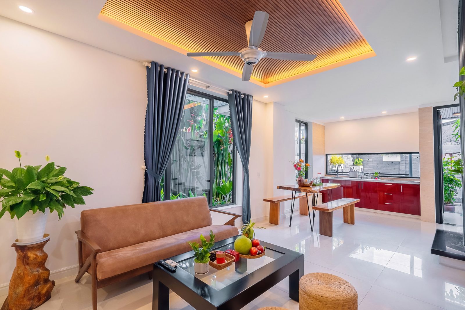 Living room with leather sofa beside the red kitchen