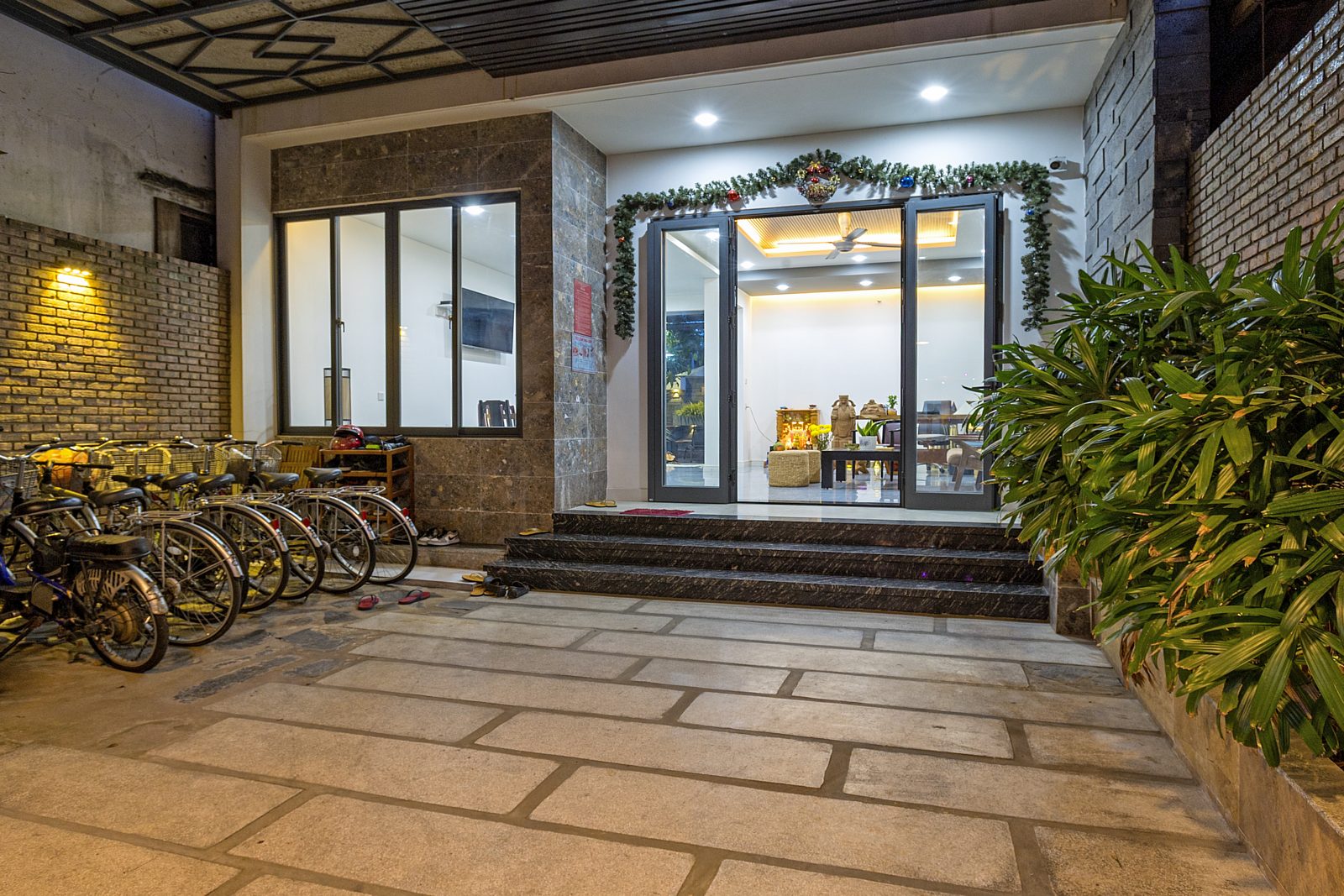 Stone-paved courtyard with a row of bicycles and glass doors to the lobby