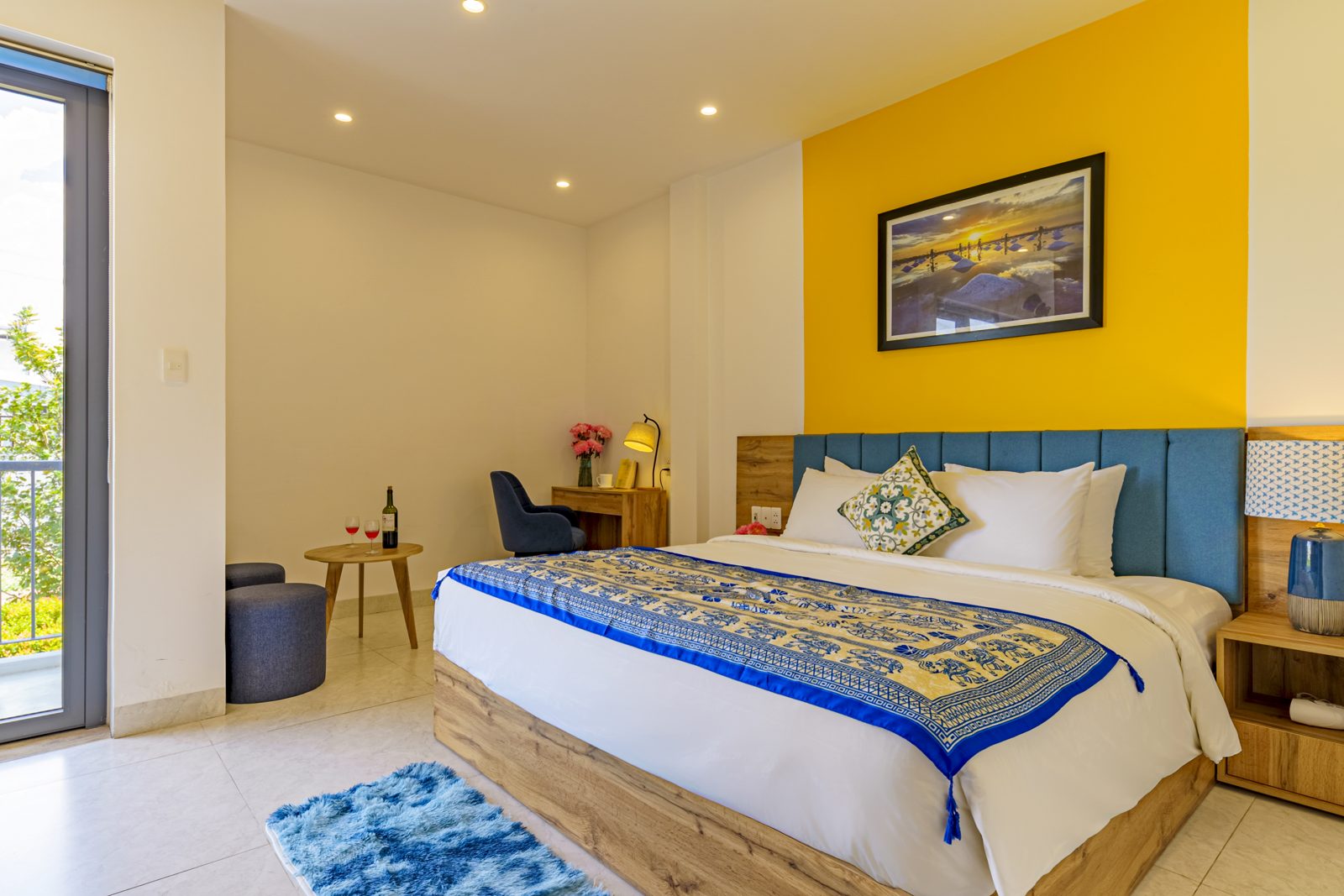 Bedroom with blue headboard and embroidered bed runner