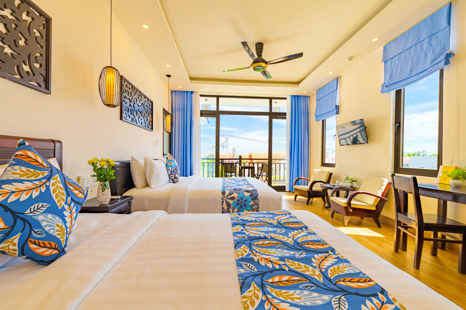 Twin-bed room with seating corner and blue blinds