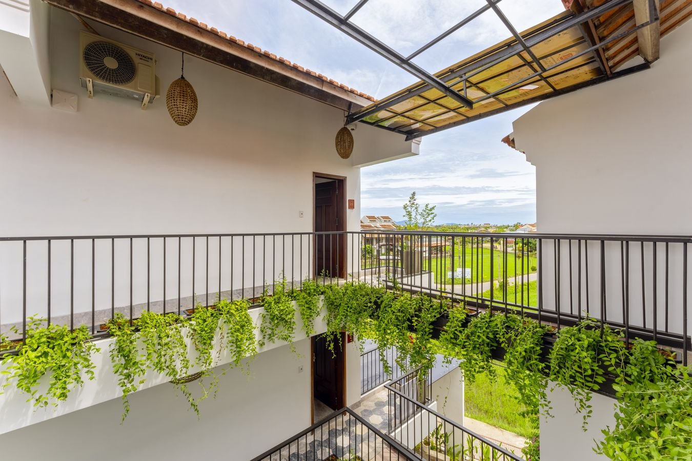 Upper walkway draped with vines overlooking rice fields