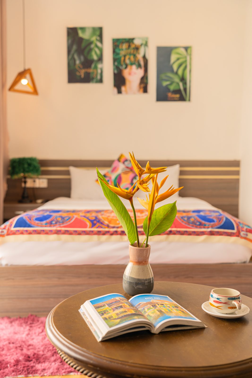 Bedroom with colourful throw, tropical flowers and botanical prints
