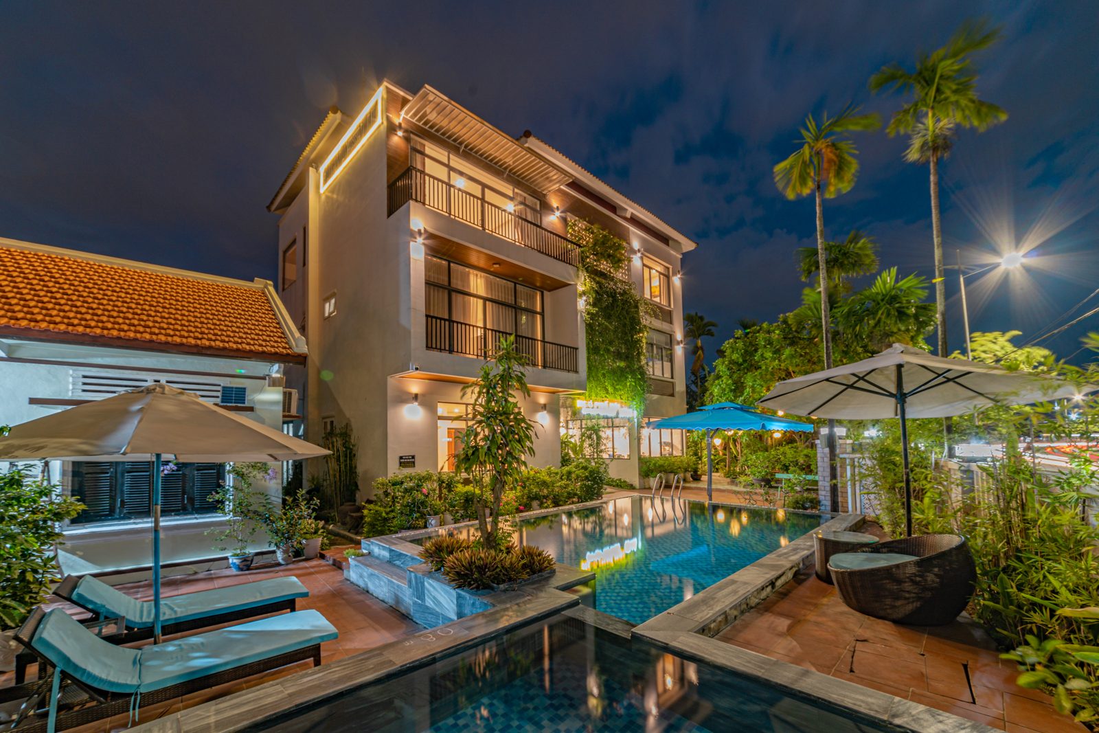 Pool and villa lit up at night