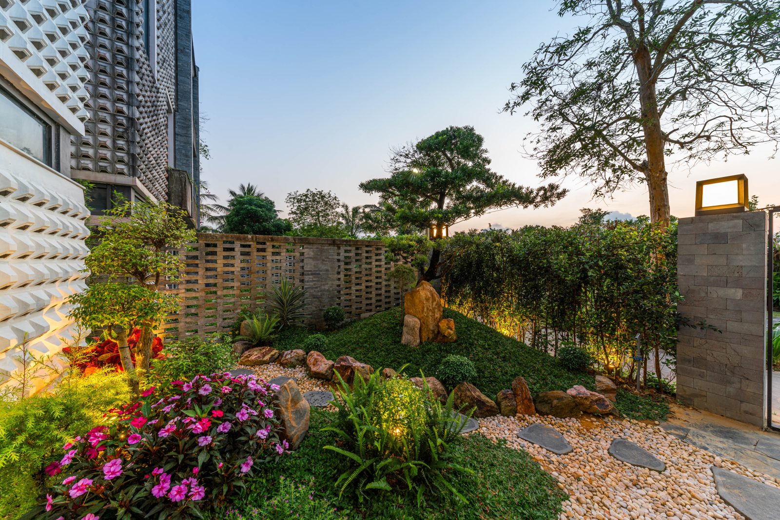 Landscaped garden with stones and flowers at dusk