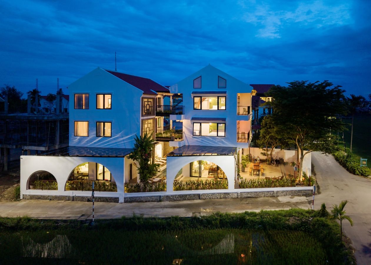 Maison de Chinh's white gables and arches lit up at night