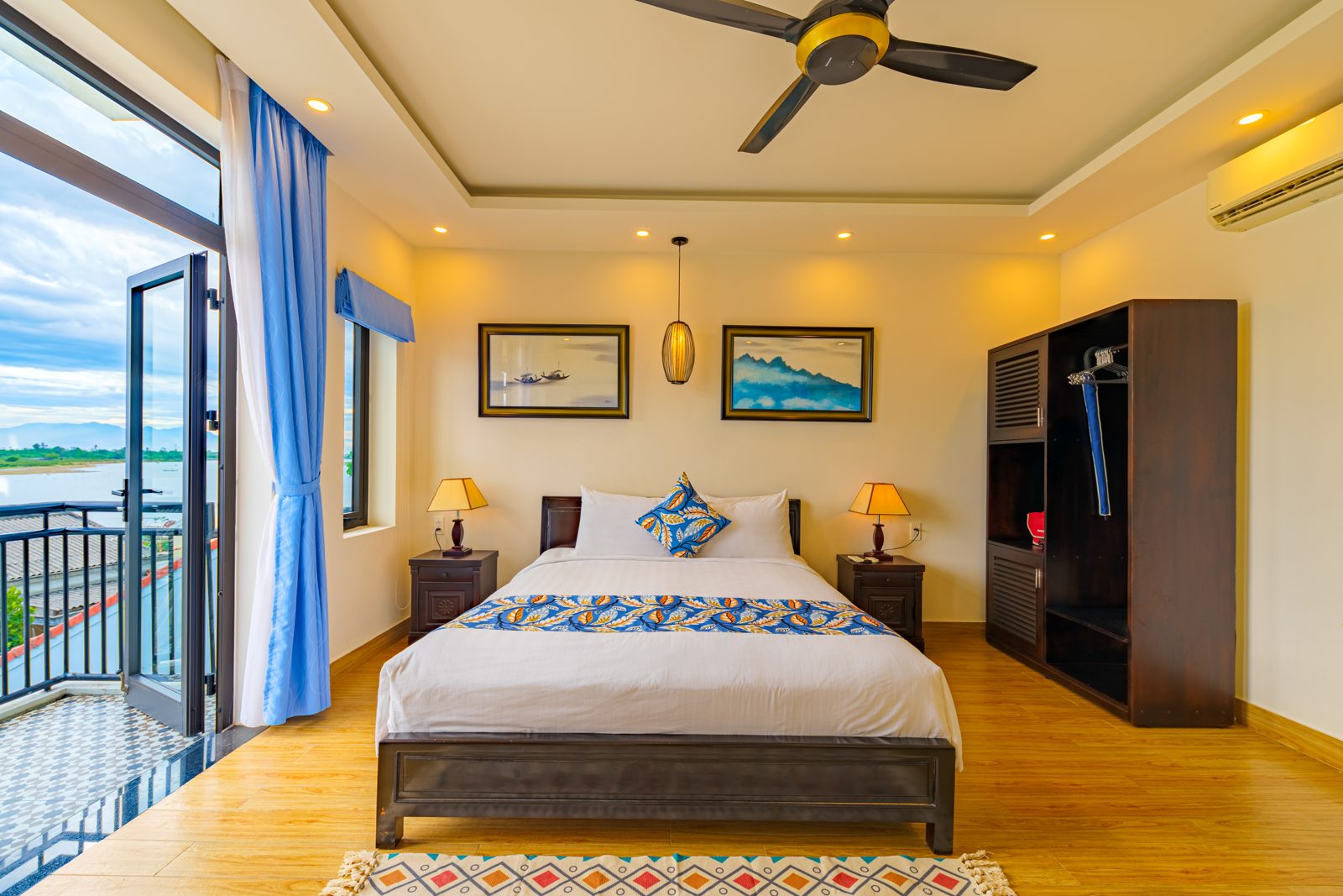 Bedroom with balcony door, blue curtains and wood floor