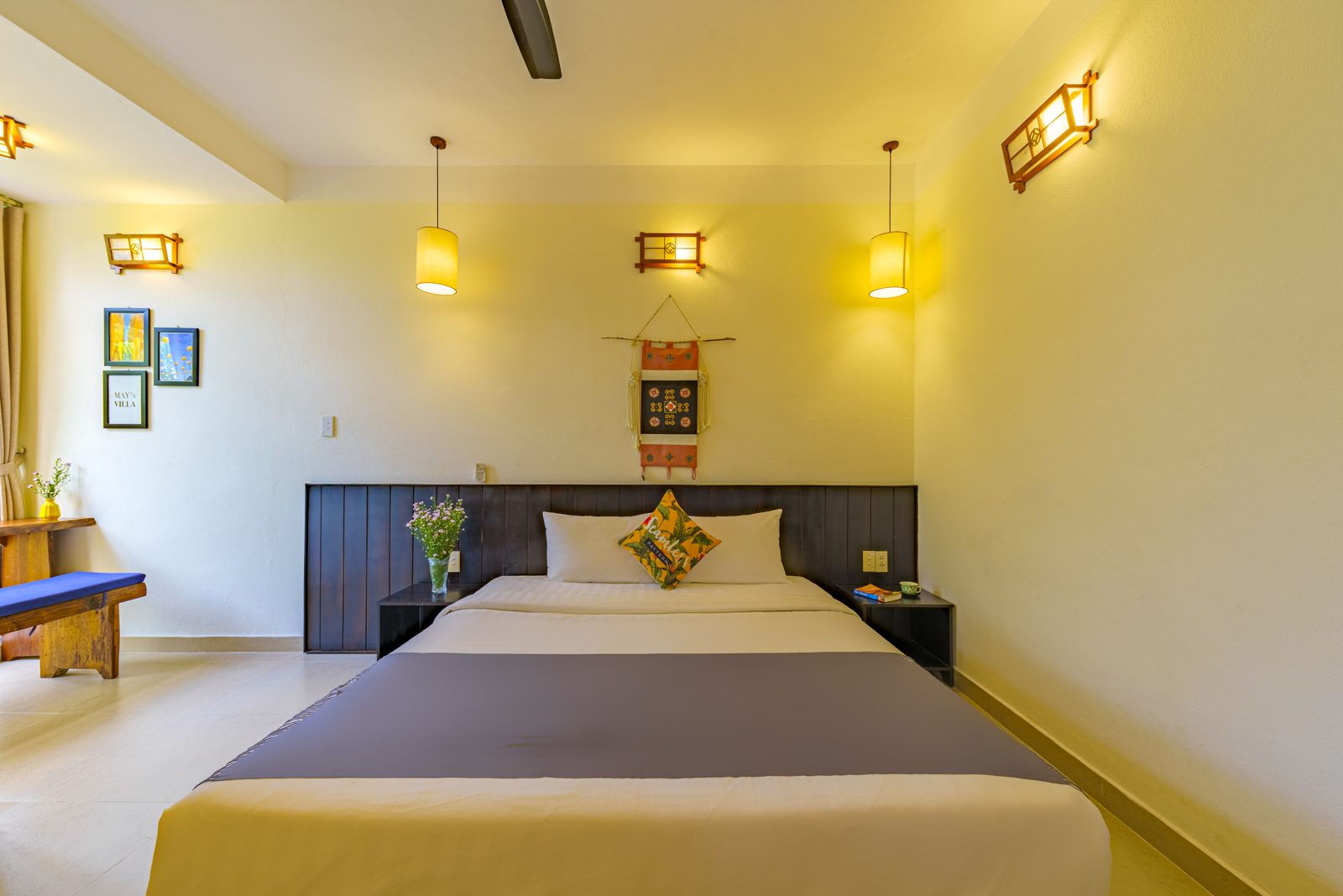 Bedroom with wall lamps and woven wall hanging
