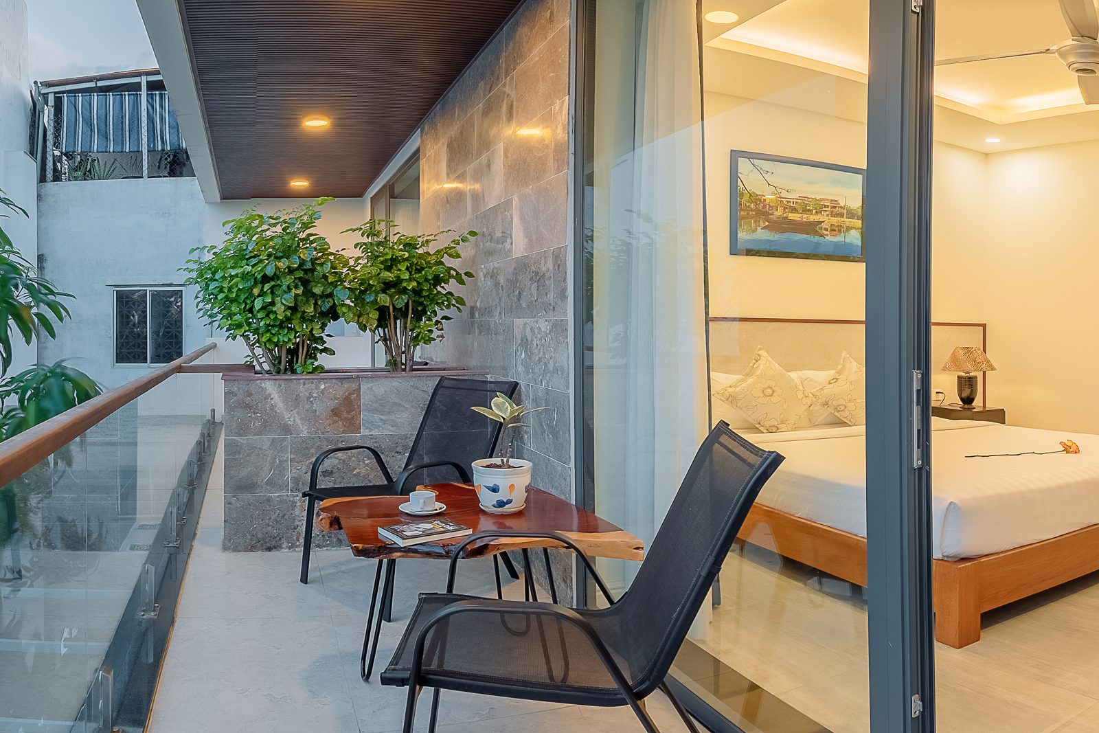 Bedroom opening onto a terrace with a small table and plants