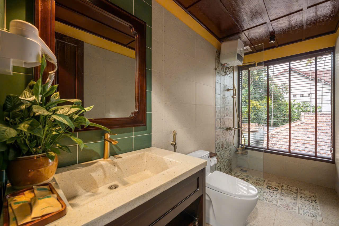 Bathroom with green tiles, wooden vanity and a garden window