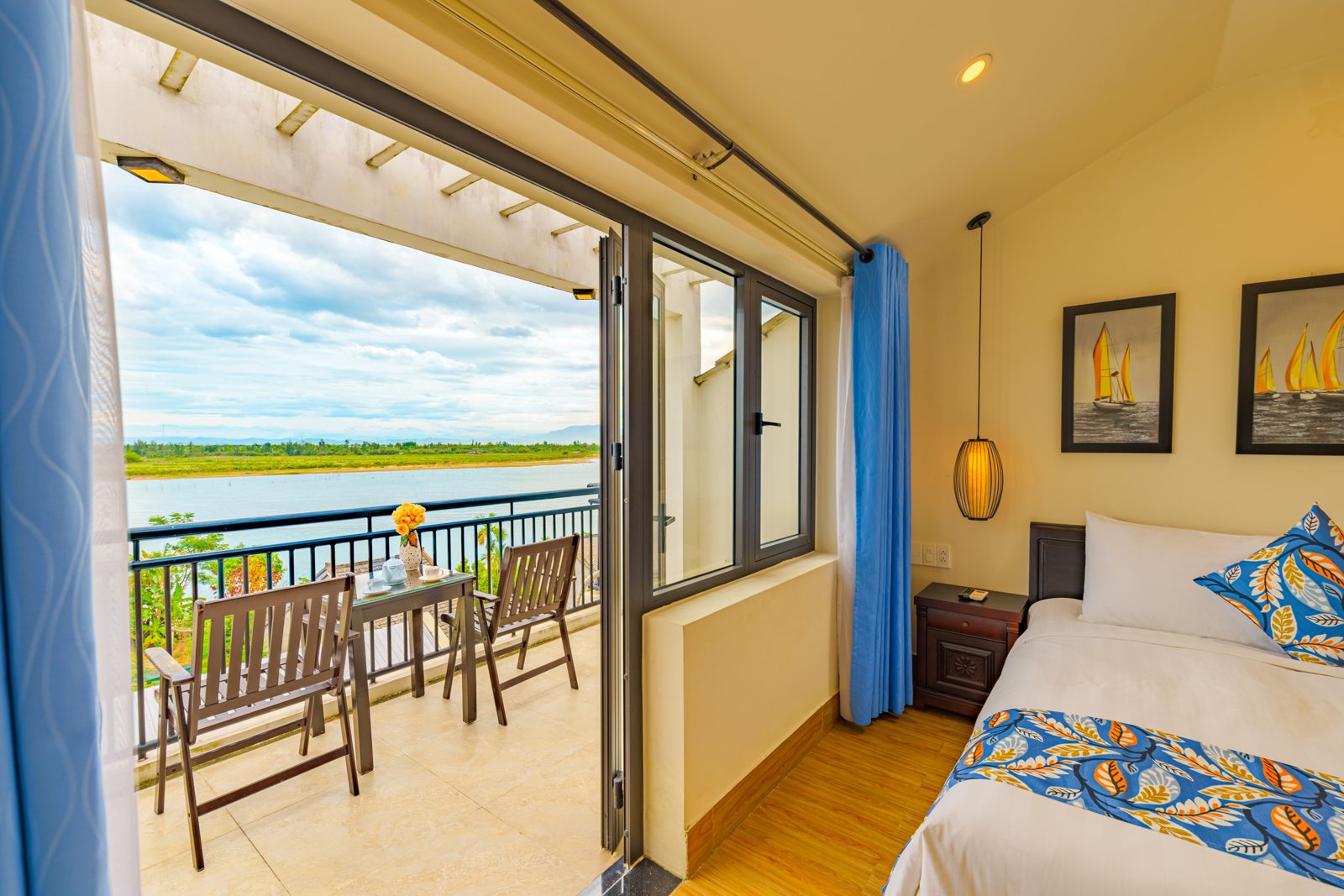 Bedroom balcony doors open onto a terrace overlooking the river
