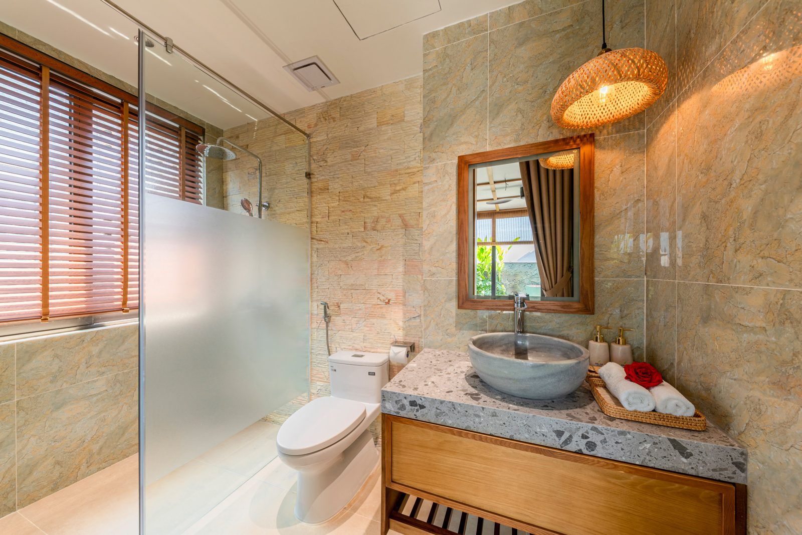 Stone bathroom with a vessel basin and glass shower