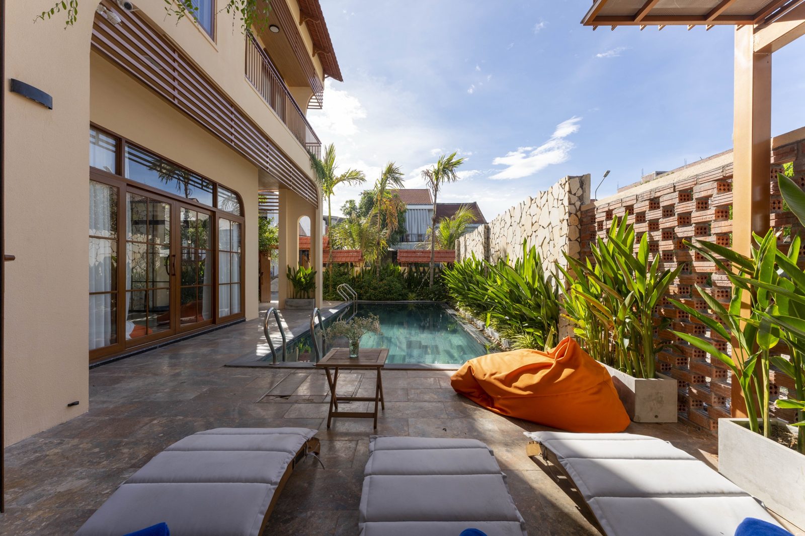 Hova Villa pool terrace with loungers and tropical planting